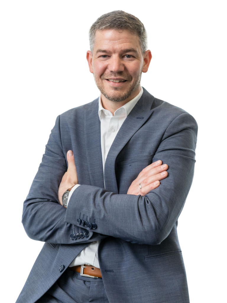 Steffen Stein, unabhängiger Finanz- und Versicherungsmakler für Beamte und junge Familien, lächelt in seinem Büro.